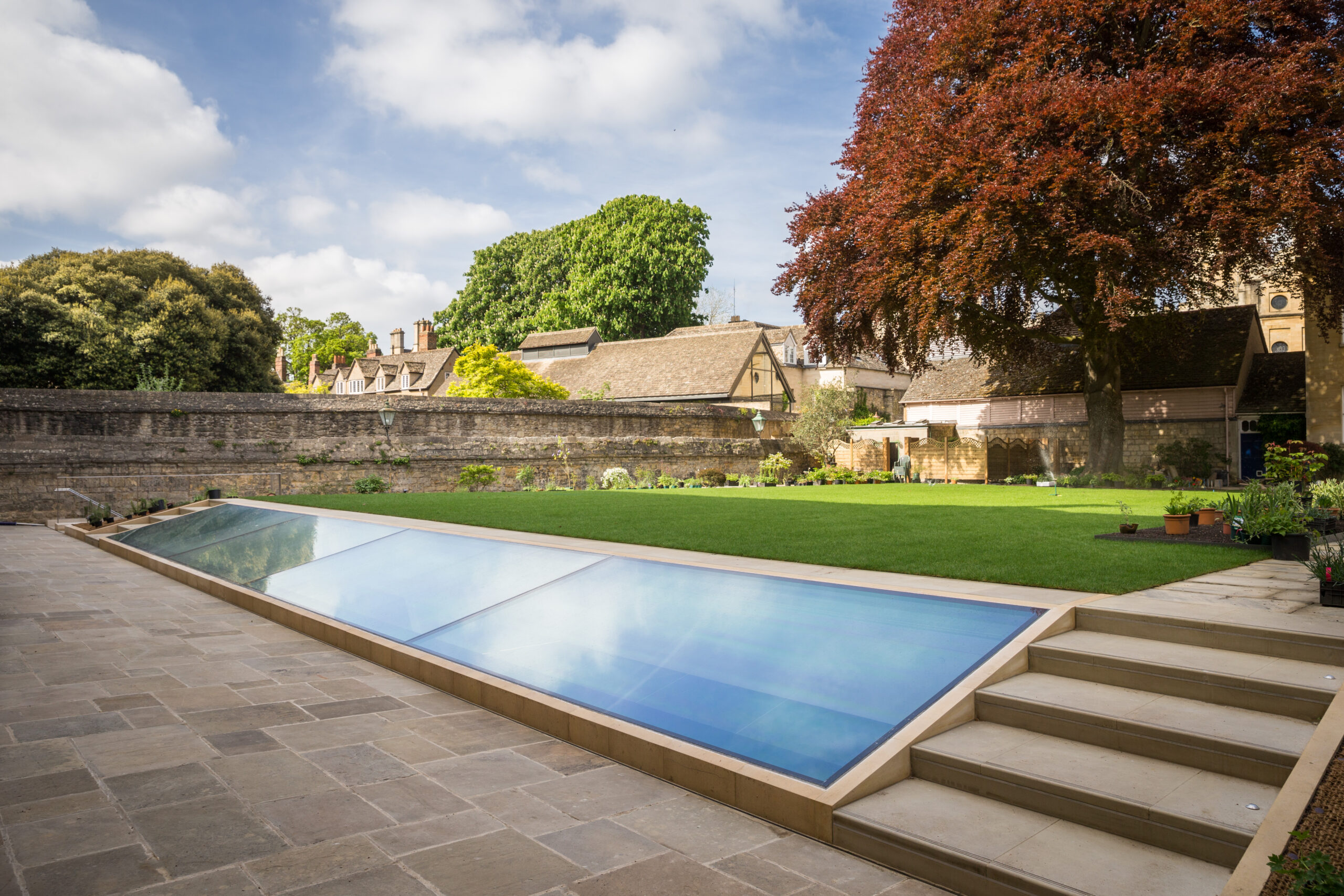 Photograph of the garden of the Provost’s lodgings at Queen’s, taken from the end nearest the Library. The photo looks out across the New Library light well, which is in the lawn of the garden, towards the old walls and Lodgings buildings.