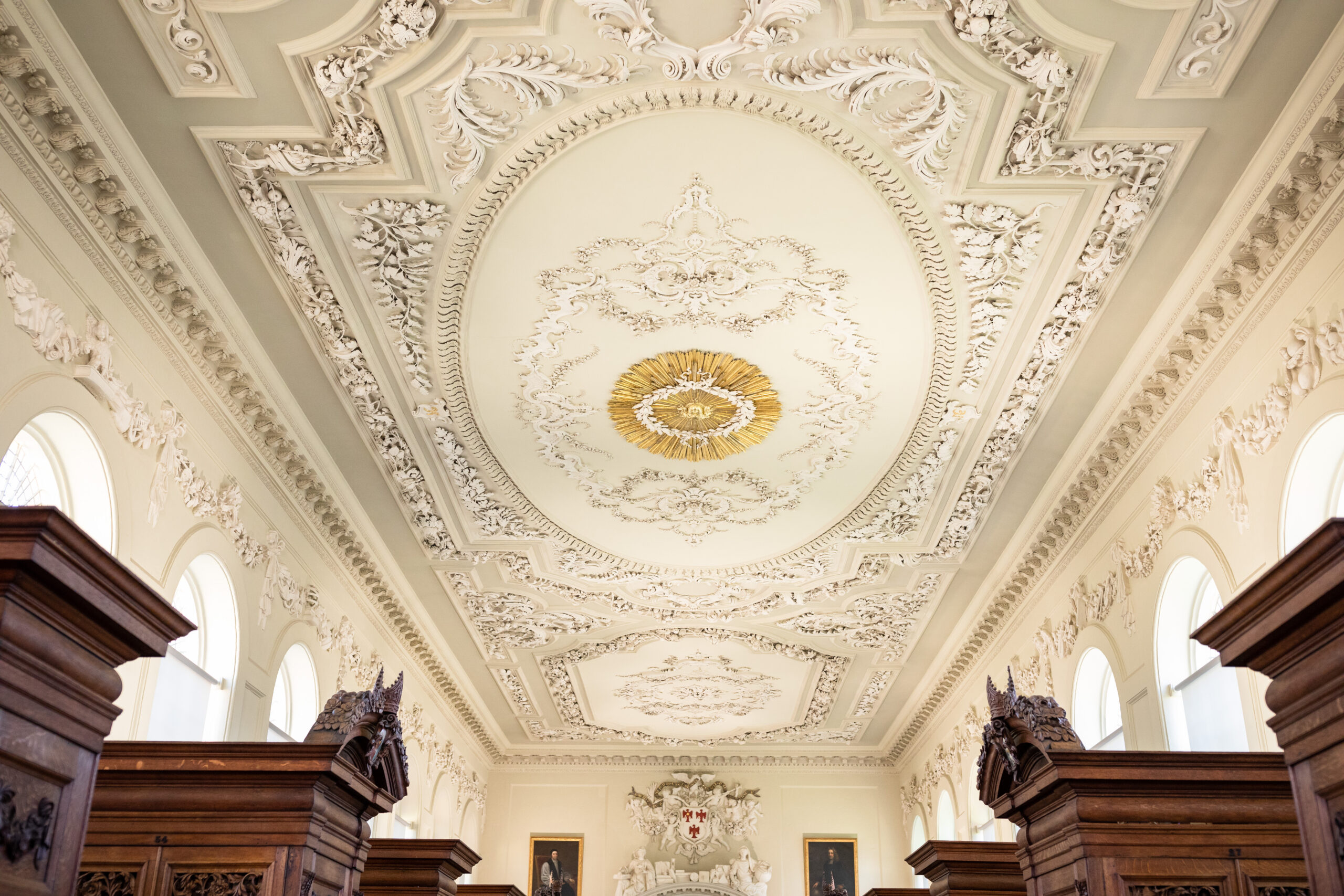 Photograph of the seventeenth-century Upper Library at Queen’s, focussing on the richly decorated baroque plaster and stucco ceiling.