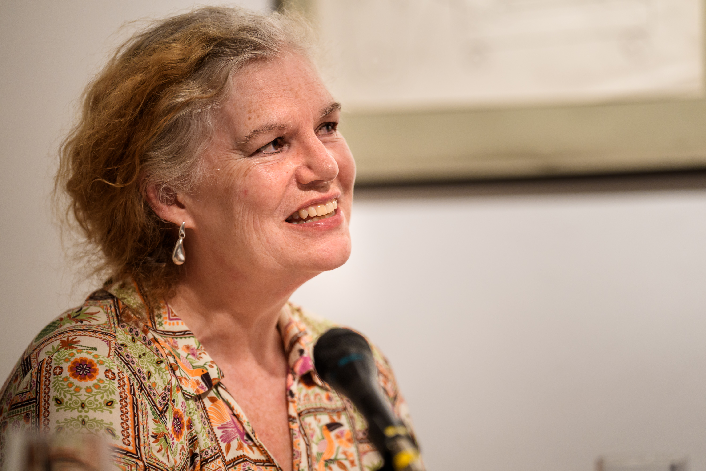 Professor Leeder profile photo. She stands at a lectern.